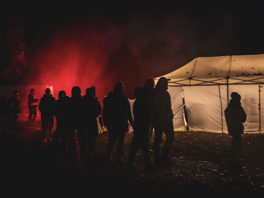 Hillerød Horrorwalk. Silhuetter af mennesker foran et oplyst telt.
